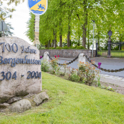 Stein mit Aufschrift "700 Jahre Bergenhusen" an einer Straße